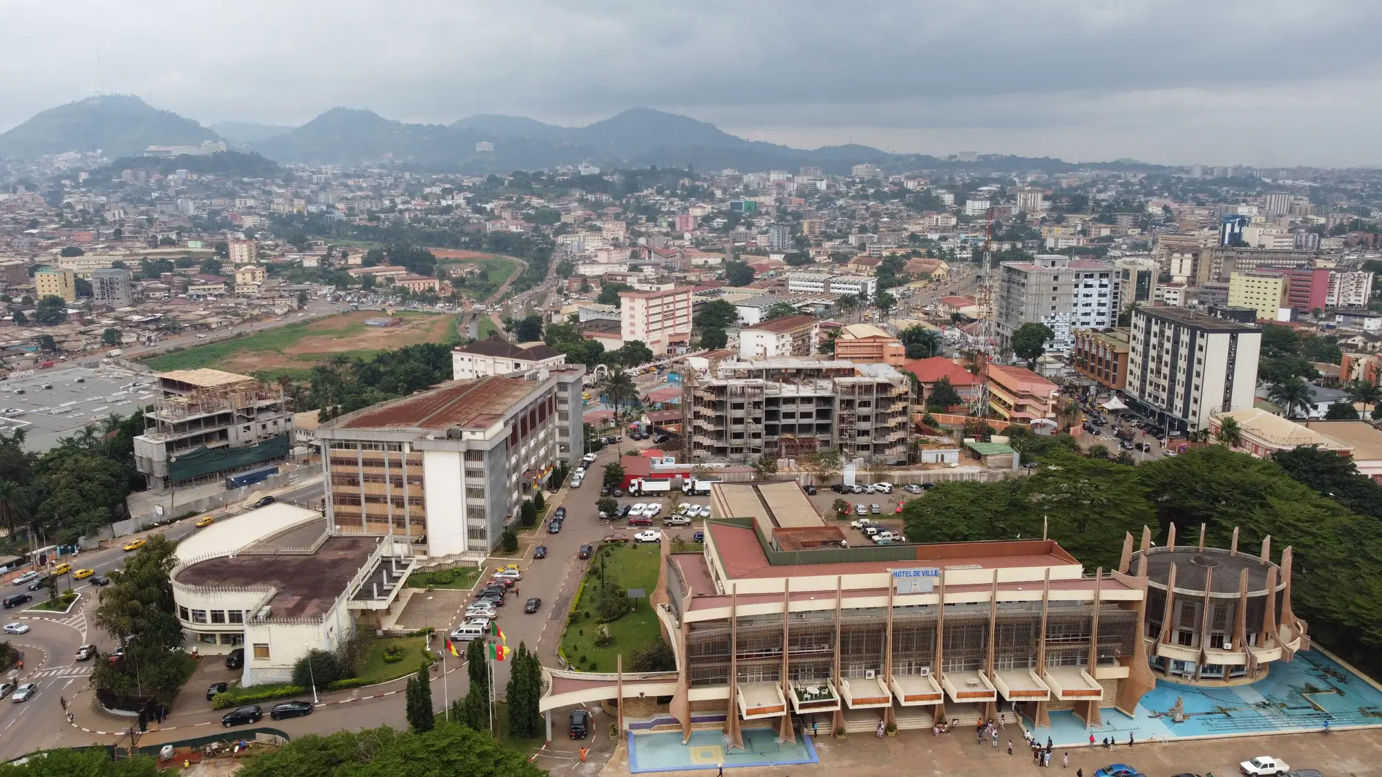 Yaoundé's buildings spreading across its hills under an overcast sky.